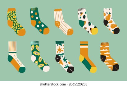 Trendy set of colored bright socks isolated on green background. Socks with different abstract prints. Vector cartoon illustration	