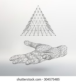 pirámide triangular en el brazo. La mano sostiene una pirámide. Triángulo de polígono. Mano poligonal. Fondo blanco. La sombra de los objetos en el fondo.