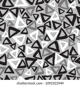 Triangles drawn hand seamless pattern-vector illustration. The triangles are black and white, on a gray background.