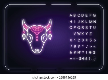 Tribal cattle head neon light icon. Cow skull with feathers. Wild animal head, mystic amulet. Outer glowing effect. Sign with alphabet, numbers and symbols. Vector isolated RGB color illustration