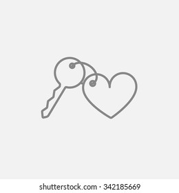 Trinket for the keys as a heart line icon for web, mobile and infographics. Vector dark grey icon isolated on light grey background.