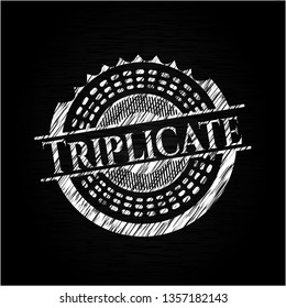 Triplicate written on a blackboard