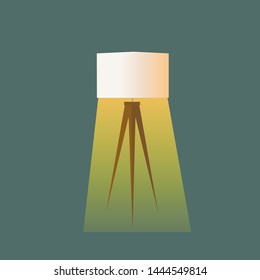 Tripod floor lamp on wooden legs with white lampshade. Gradient golden glowing light on dark turquoise background. Room fragment interior decoration