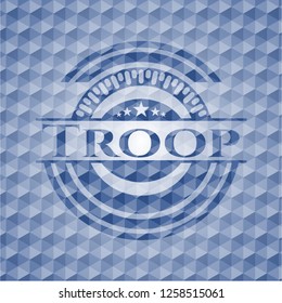 Troop blue badge with geometric pattern background.