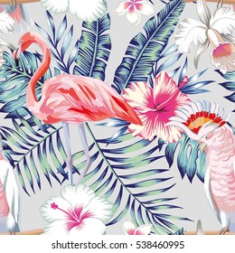 Tropical bird pink flamingo and parrot macaw banana palm leaves in trendy blue style and flowers hibiscus, frangipani, orchid. Seamless vector pattern