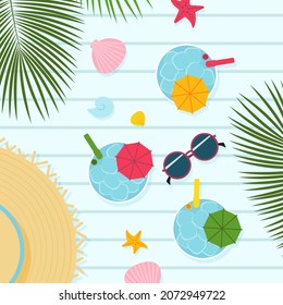 Tropical cocktails and hat on a wooden table. Top view. 