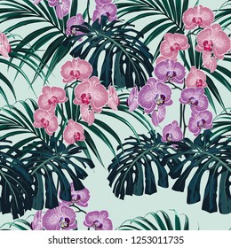 Tropical exotic plants seamless pattern, monster, palm leaves and pink violet orchid flowers . Decoration on mint background. Colorful exotic rainforest wallpaper.