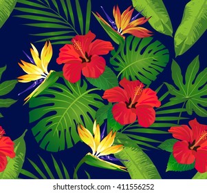 Tropical flowers and leaves on dark blue background. Seamless. Vector.