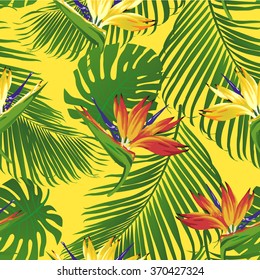 Tropical flowers and leaves on yellow background. Strelitzia and leaves of palm. Seamless. Vector.