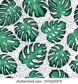 tropical hand drawn seamless pattern with green monstera leaves and dots on the background