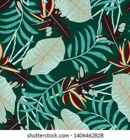 Tropical seamless pattern with bright leaves and plants on green background. Vector design. Jungle print. Printing and textiles.