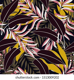 Tropical seamless pattern with dark and yellow leaves and plants on black background. Exotic jungle wallpaper. Hawaiian style. Exotic wallpaper.