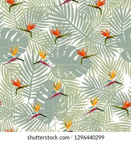 Tropical seamless pattern of flowers bird of Paradise (strelitzia) on the background of palm leaves. Exotic illustration of jungle plants.