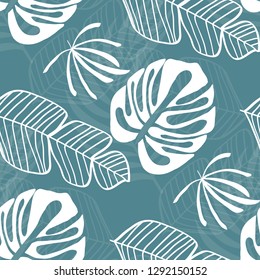 Tropical seamless pattern with leaves. White tropical leaves on blue background. 