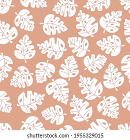 Tropical seamless pattern with monstera leaves. Plants white silhouette on beige background. Ideal for fashion fabric, textile and print wallpaper. Vector illustration.