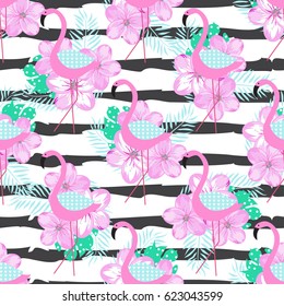 Tropical seamless pattern with pink flamingo, flowers and palm leaves. Vector illustration.