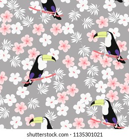 Tropical seamless pattern with toucan, flowers and leaves. A tropical forest with birds. Stylish tropical background with toucan.