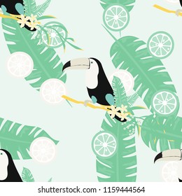 Tropical seamless pattern with toucan, tropical leaves and citrus. Lemon and lime. Summer background with tropical birds.