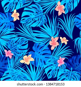 Tropical vector seamless pattern, blue branches and flowers on dark background. Botany design, jungle leaves of palm tree and flowers.