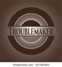 Troublemaker badge with wood background