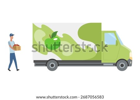 A truck driver loads boxes of apple juice into a truck. A man holds a basket of apples by a green delivery truck