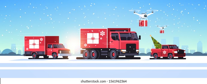 trucks pickup car driving road quadcopters with gift boxes delivery shipping transport merry christmas happy new year winter holidays concept horizontal snowy cityscape background vector illustration