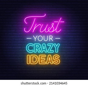 Trust Your Crazy Ideas neon lettering on brick wall background.