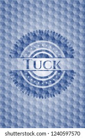 Tuck blue badge with geometric pattern background.
