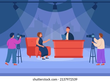 TV talk show with female celebrity flat vector illustration. Woman sitting on sofa and talking with host, discussing news in studio. Videographers filming broadcasting. Television, interview concept