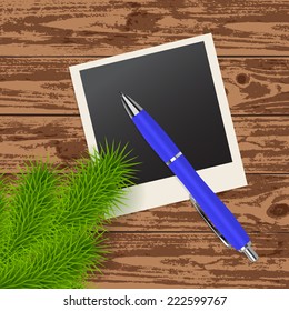 twig tree, photo frame and blue pen on the wooden background