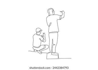 Two artists painting city walls sitting and standing