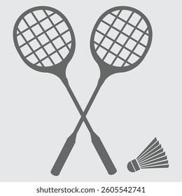 Two badminton rackets with a shuttlecock on a court surface.