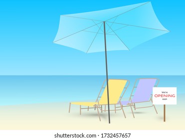 Two beach chair and a blue umbrella on the beach. Lettering we are opening soon on the beach, taking vacation after coronavirus outbreak.