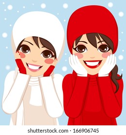 Two beautiful brunette women friends in warm red and white clothing outdoors on winter snow day with hands on cheeks