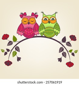 Two beautiful owls on a branch with flowers