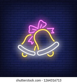 Two bells with ribbon bow neon sign. Christmas and celebration design element. Night bright neon sign, colorful billboard, light banner. Vector illustration in neon style.