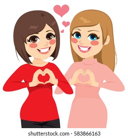 Dos mejores amigas chicas sonrientes mostrando gesto de corazón con las manos