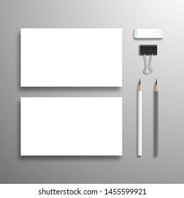 Two blank horizontal business cards, lead pencils, eraser and binder.  Flat lay mockup with shadow