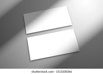 Two blank white cards lie on the surface. Image in perspective. Template for design with shadow from the window