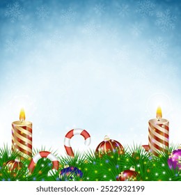 Two burning Christmas candles with Christmas balls, candy canes and pine branches in snowfall on blue background