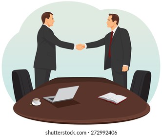 Two businessmen in suits are handshaking in the office