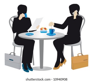 Two businesswomen at a table drinking coffee.
