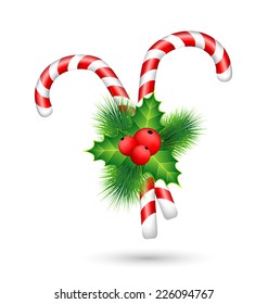 Two candy canes with holly sprig isolated on white background