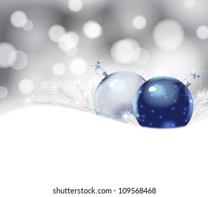 Two Christmas baubles and fir branches on bokeh background