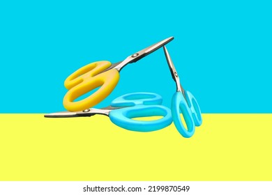 Dos tijeras de color amarillo, azul sobre azul turquesa, fondo amarillo. 