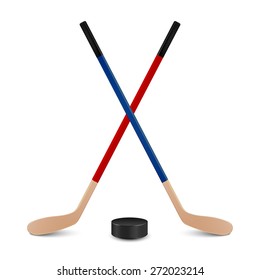 Two crossed hockey sticks - red and blue - and puck. Isolated on white background. Vector EPS10 illustration. 