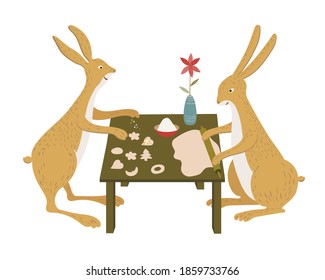 Two cute hares cooking in the kitchen. Rabbits are making cookies isolated on a white background. Preparing for Christmas.