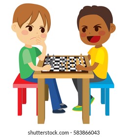 Two cute kid friends sitting playing chess game board