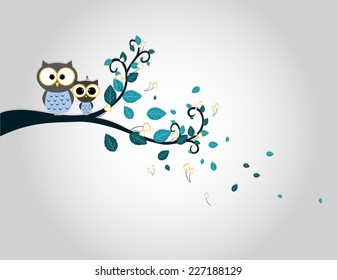 Two cute owls on a tree branch silhouette