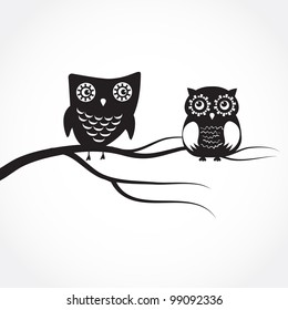 Two cute owls on the tree branch